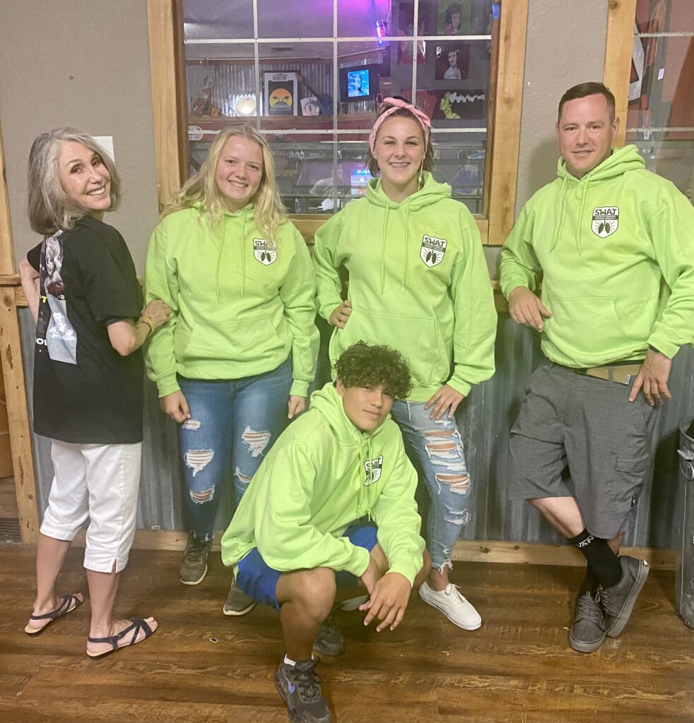 4 teenagers and one adult posing in SWAT lime green sweatshirts